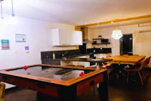 Loft Nature Bien Etre, field hockey on table and fully equipped and functional kitchen in the background vacation rental Tarn