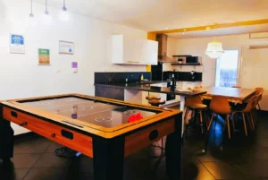 Loft Nature Bien Etre, field hockey on table and fully equipped and functional kitchen in the background vacation rental Tarn