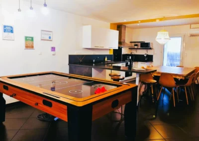 Loft Nature Bien Etre, field hockey on table and fully equipped and functional kitchen in the background vacation rental Tarn